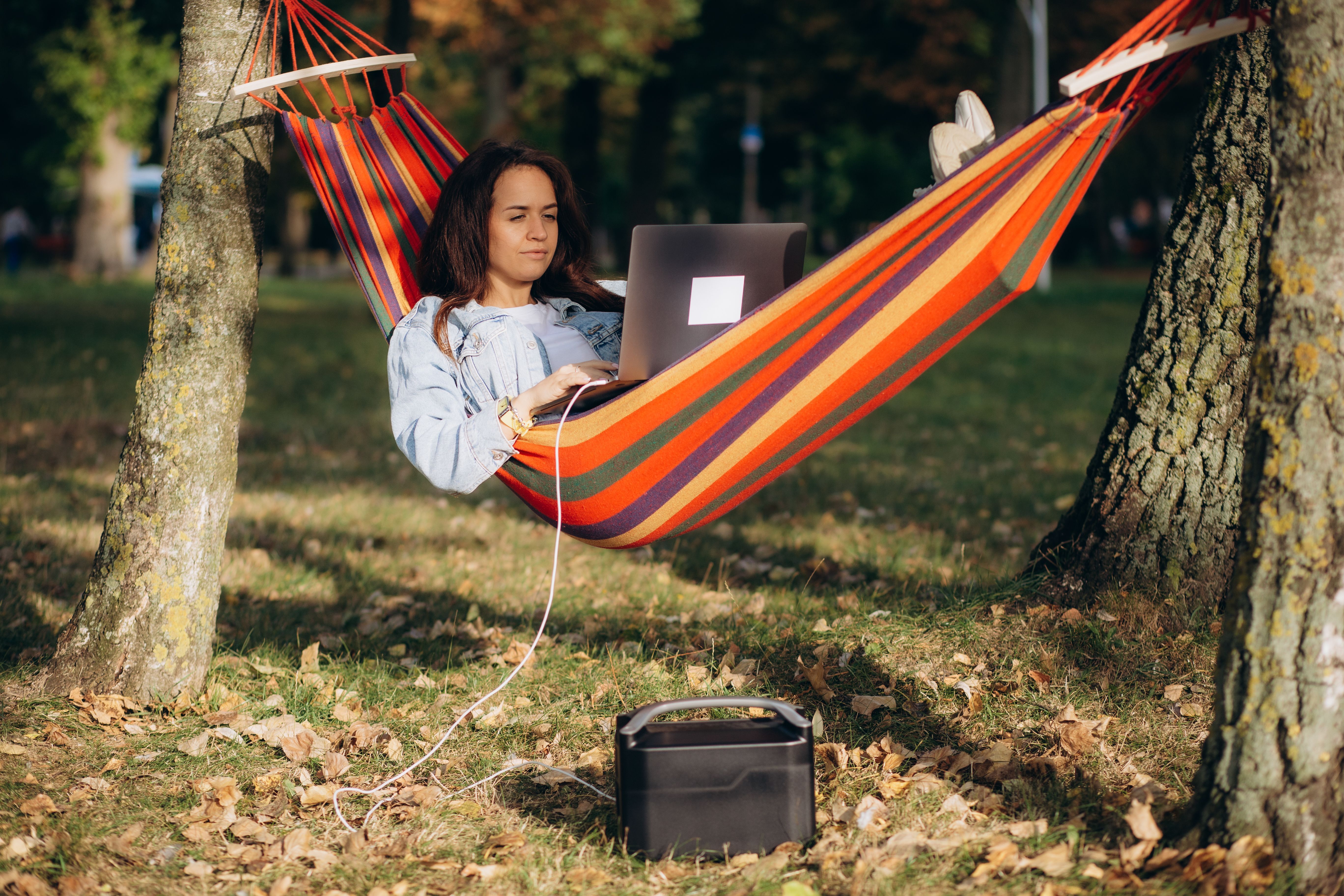 a digital nomad woman working remotely from her hammock as part of her RV office setup